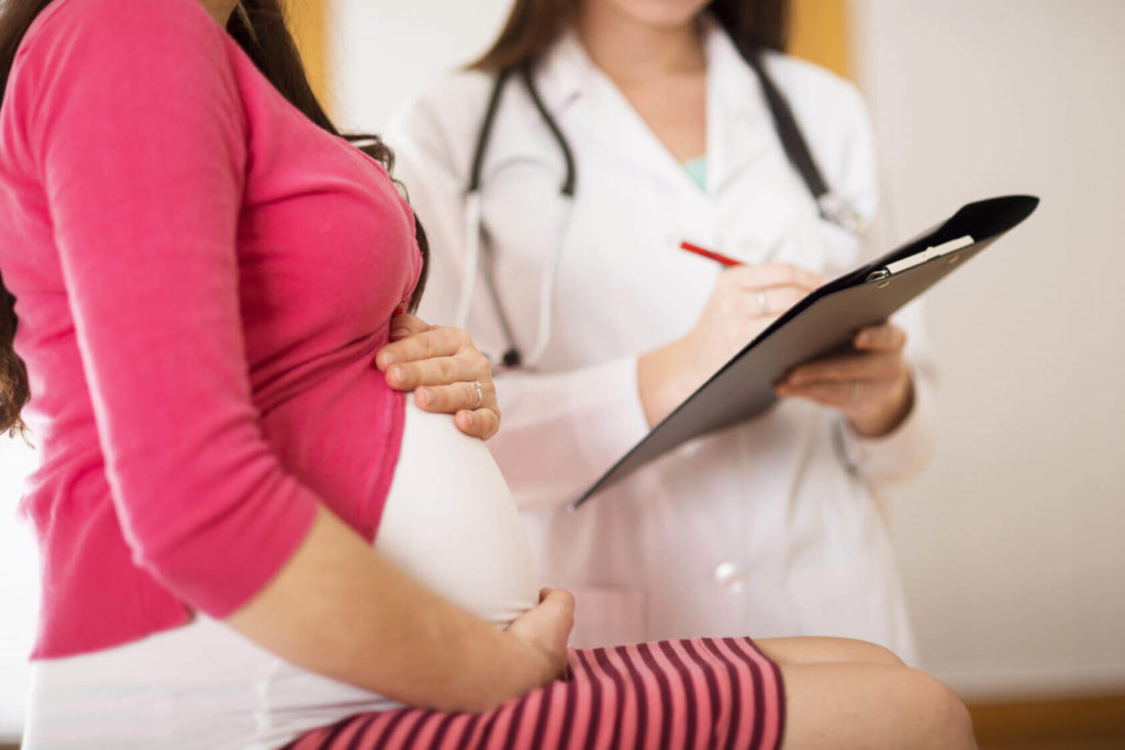 Беременная женщина на приеме у врача клиники репродуктивной медицины Надежда
